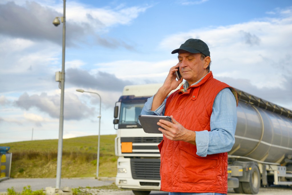 Truck driver using his cellphone and ipad