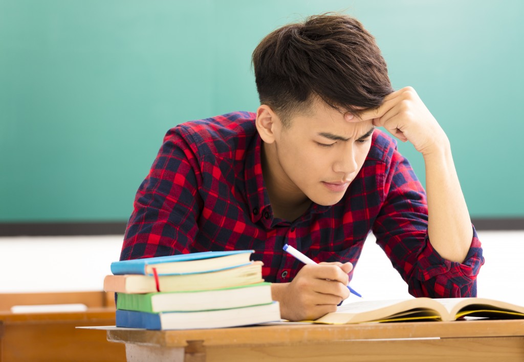 Stressed student studying in the classroom