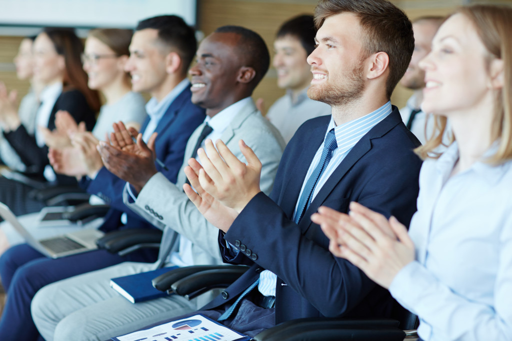 employees clapping while smiling in an event