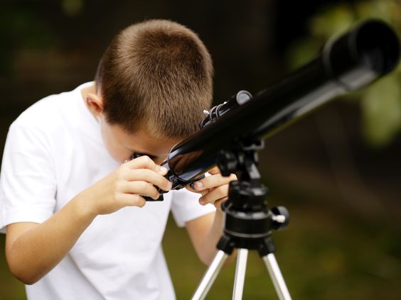 boy looking through the telescope