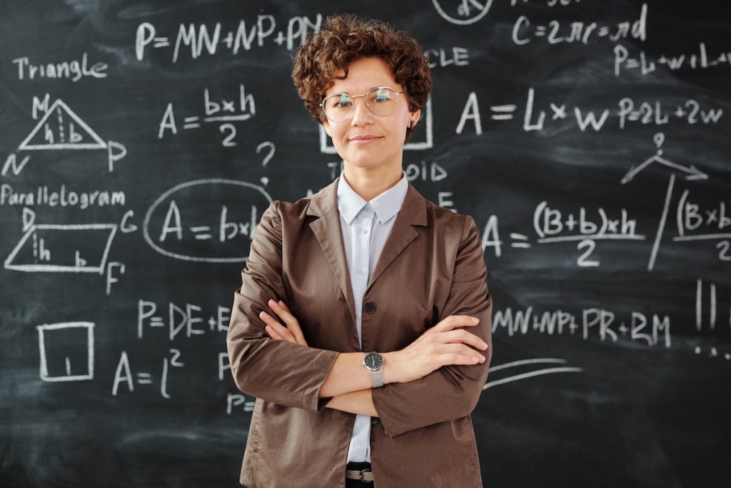 Photo Of Woman Standing In Front Of Blackboard